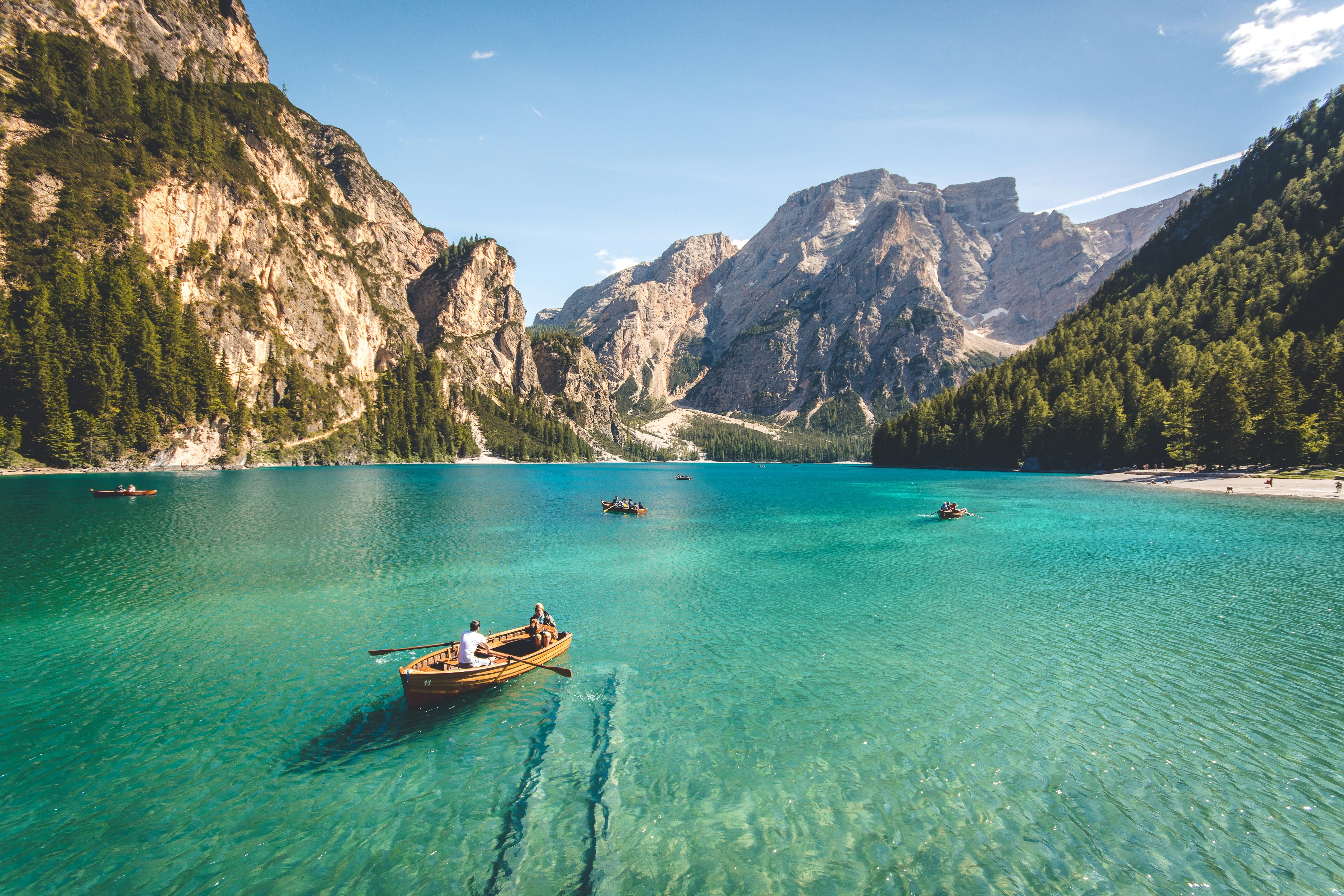 Lac de montagne turquoise avec bateau et sommets alpins